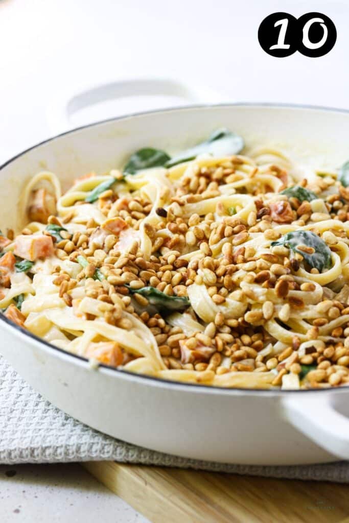 finished pasta topped with pine nuts in a pan
