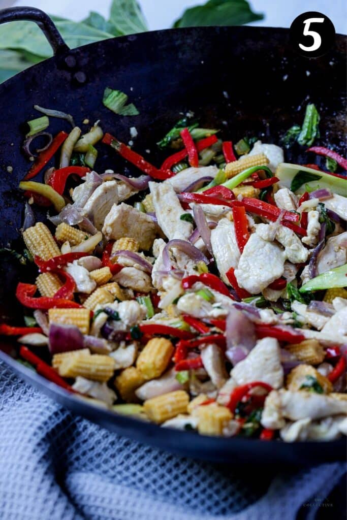 vegetables and chicken stir fried in a wok