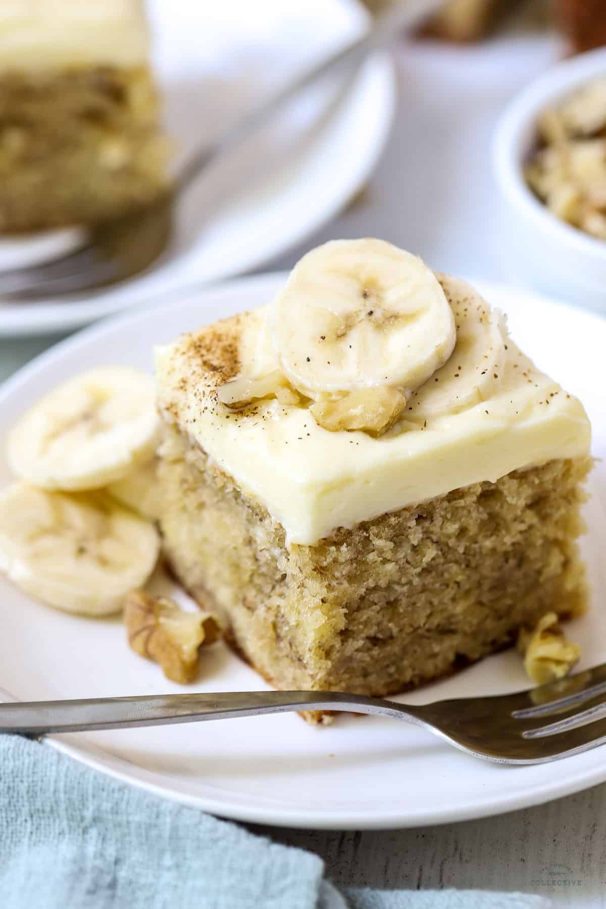 a slice of banana cake on a white plate with a fork