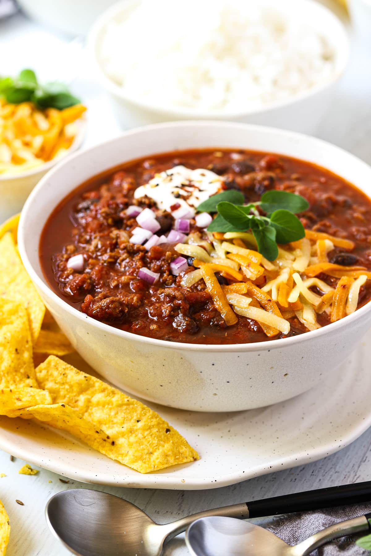 a finished bowl of chilli with black beans, cheese and tortillas