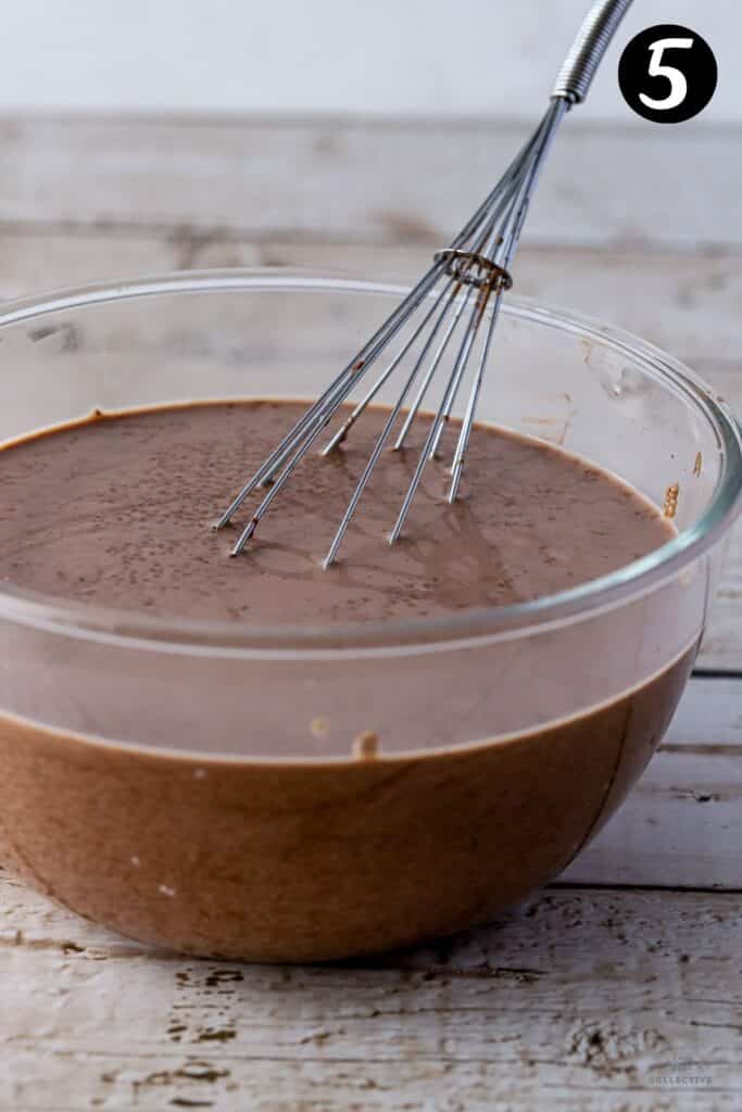 chocolate chia pudding in a glass bowl with a whisk