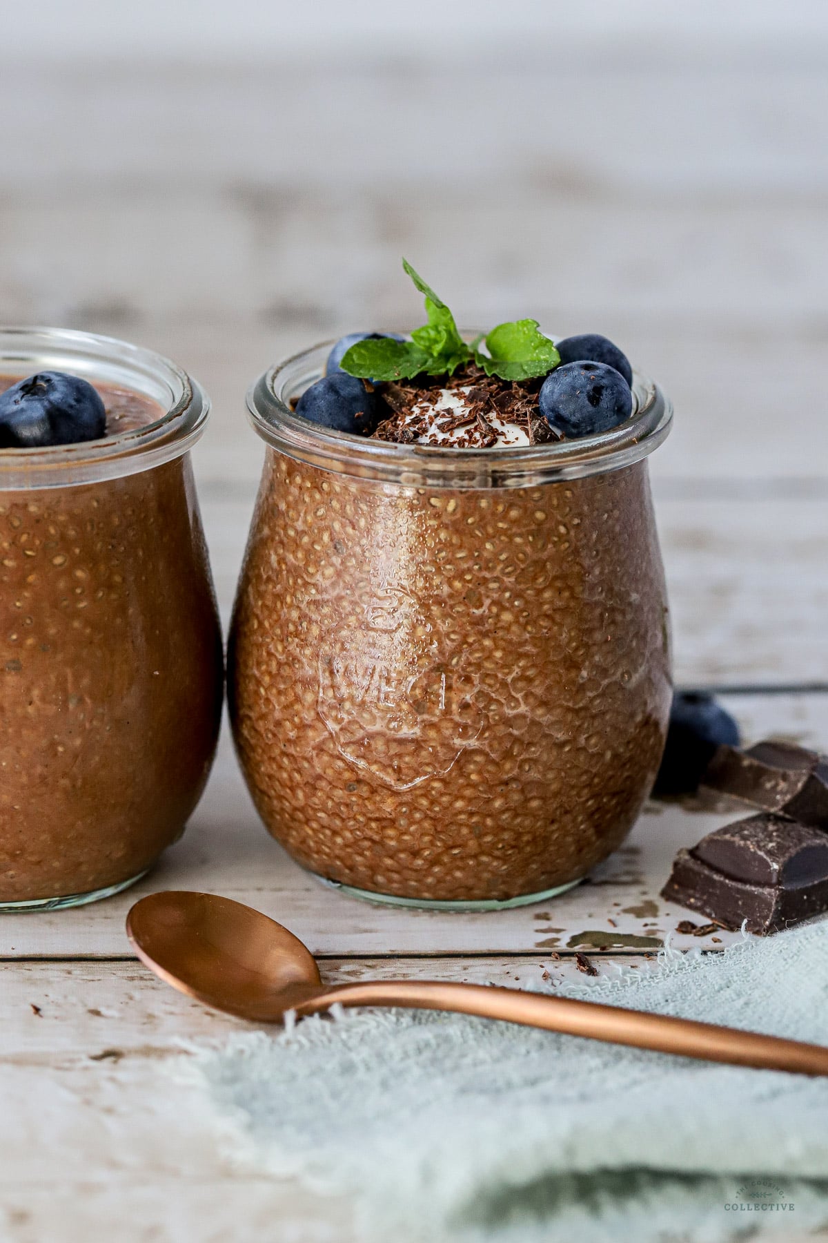 chocolate chia pudding in glass jars topped with berries