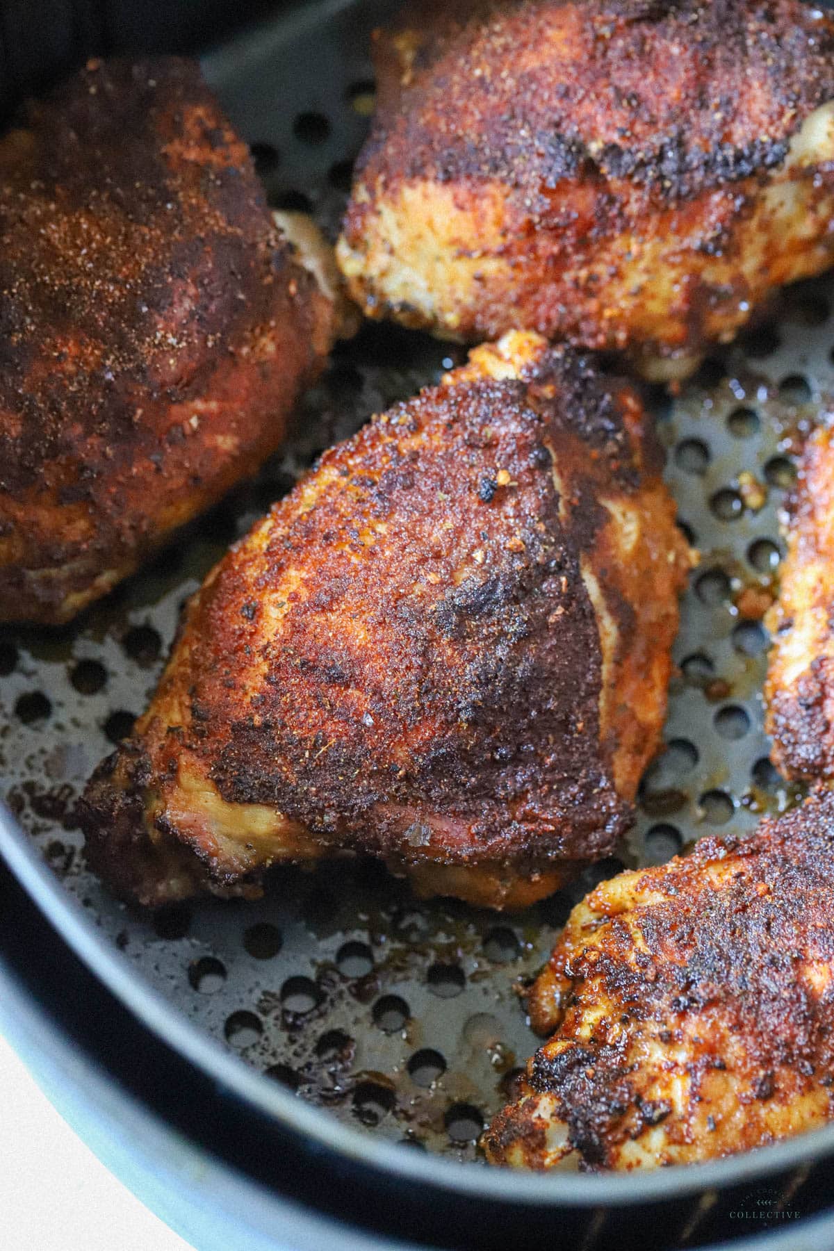 cooked chicken thighs in an air fryer basket