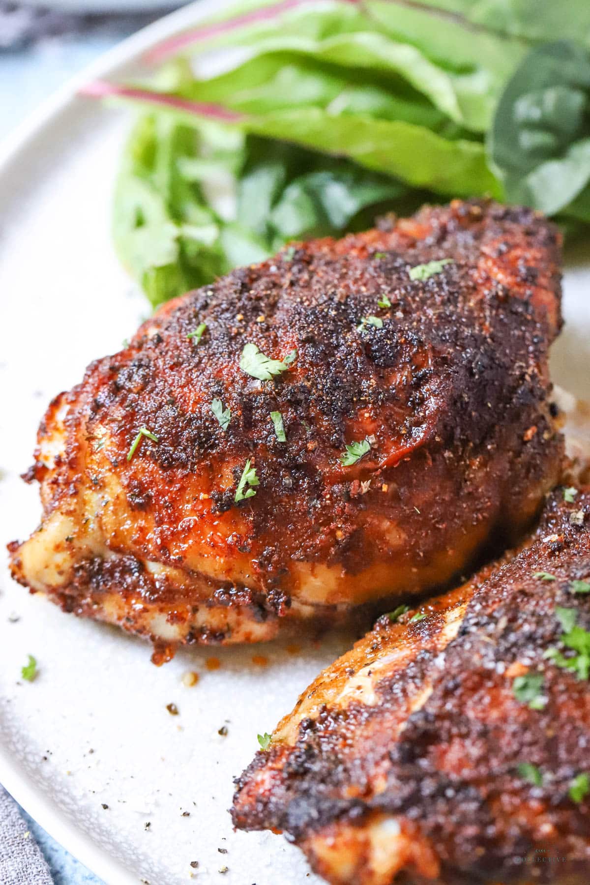 chicken thighs on a grey plate with salad