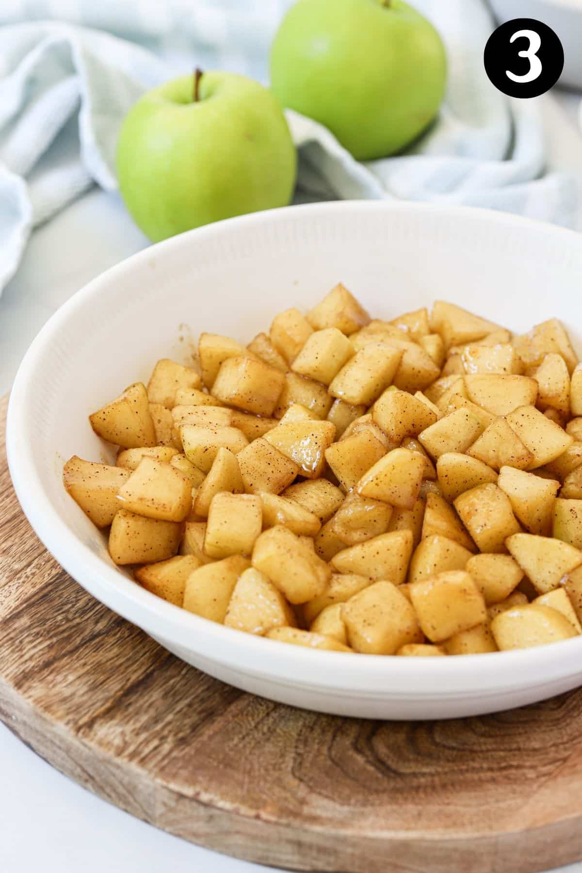 cooked apples in a white baking dish
