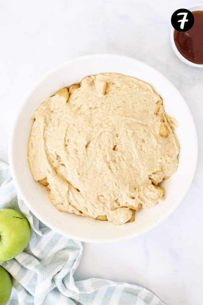 sponge batter spooned over apples in a baking dish