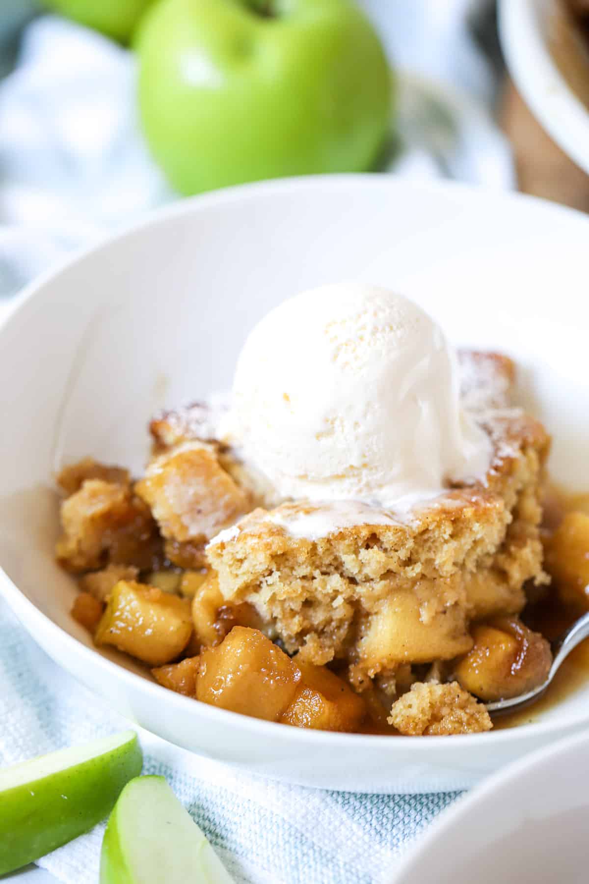 finished sponge pudding in a white bowl with a scoop of ice cream