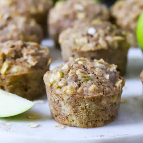 apple muffins on a white plate with apple slices