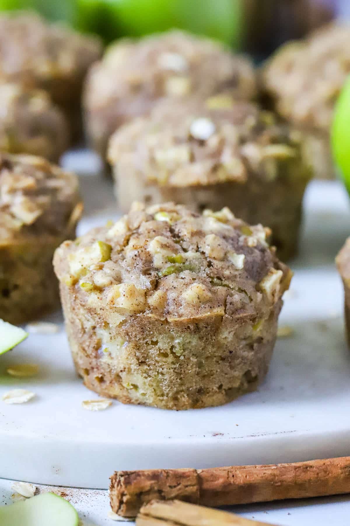 an apple muffin on a white plate with a cinnamon stick