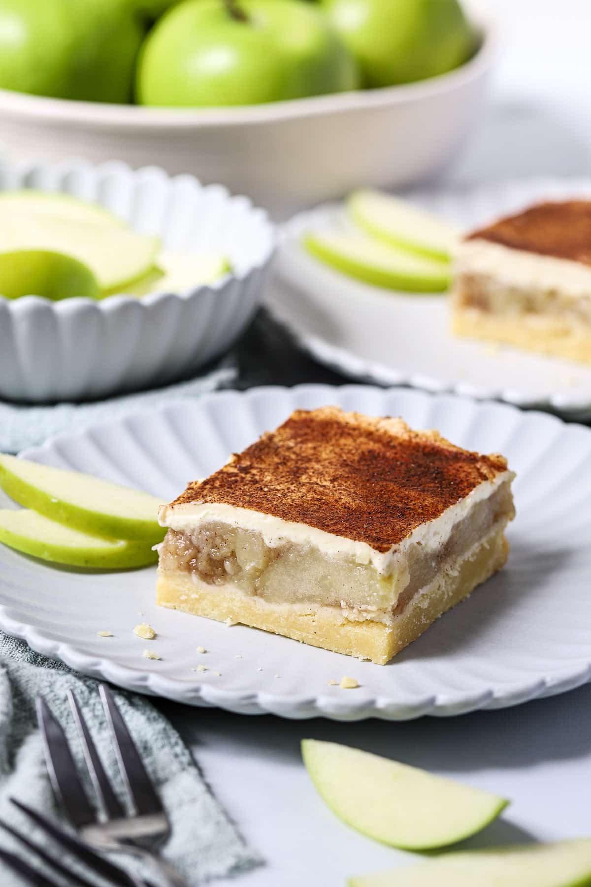 apple sour cream slice on a white plate with apple slices