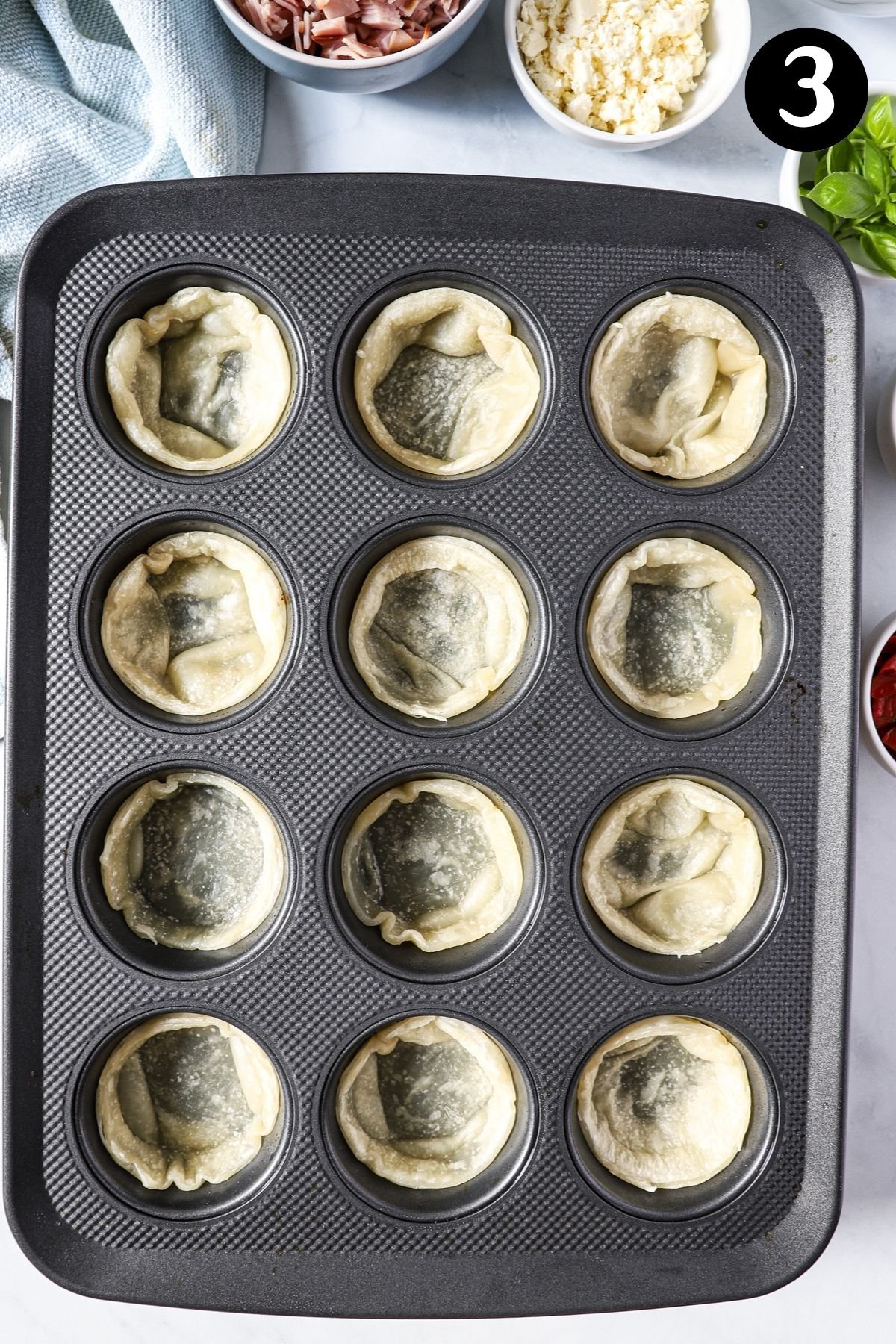 blind baked puff pastry in a muffin tray