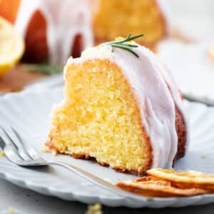 a piece of lemon syrup cake with a glaze and rosemary