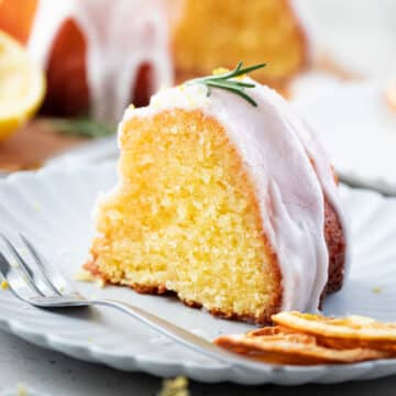 a piece of lemon syrup cake with a glaze and rosemary