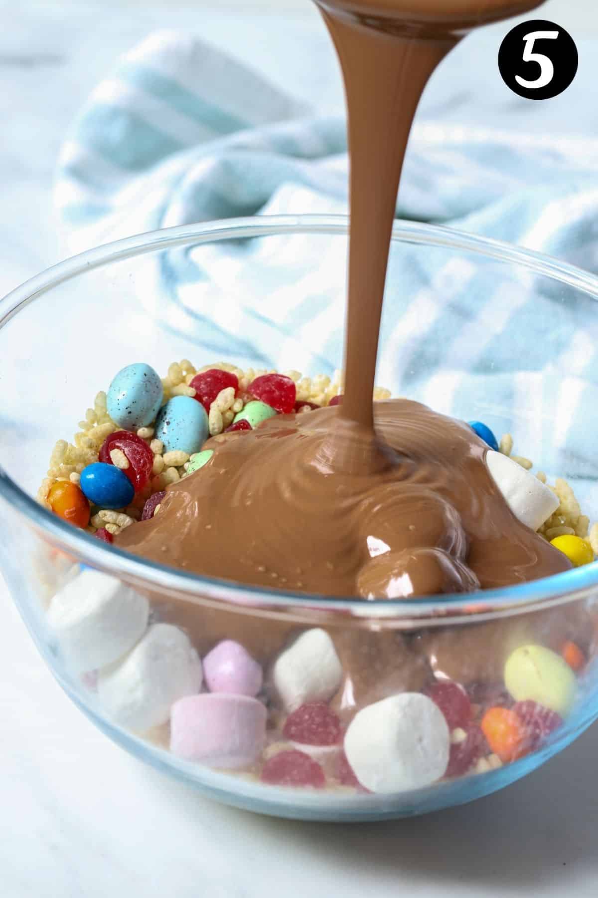 melted chocolate being poured over rocky road filling