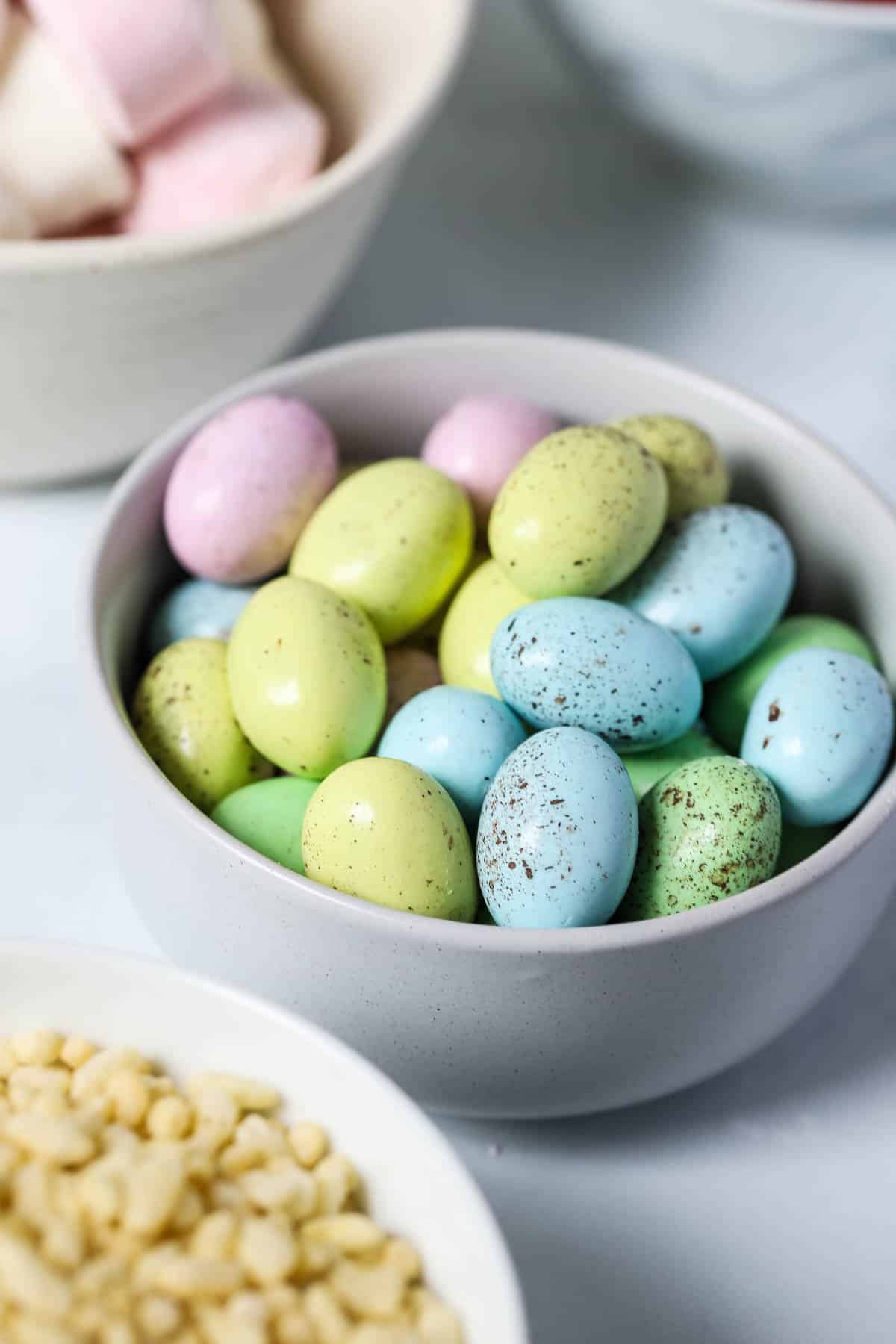 speckled chocolate mini eggs in a bowl on a white table