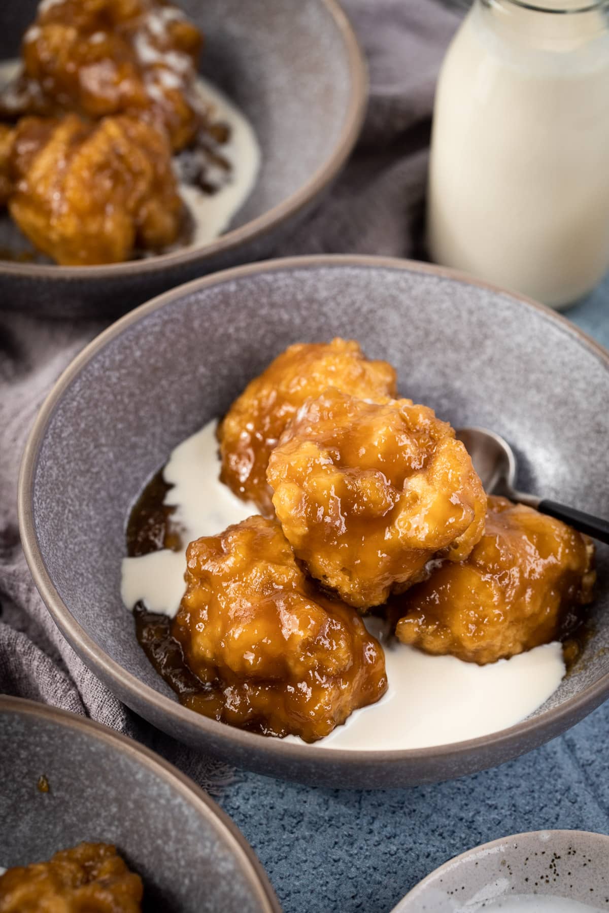 golden syrup dumplings in a bowl with cream