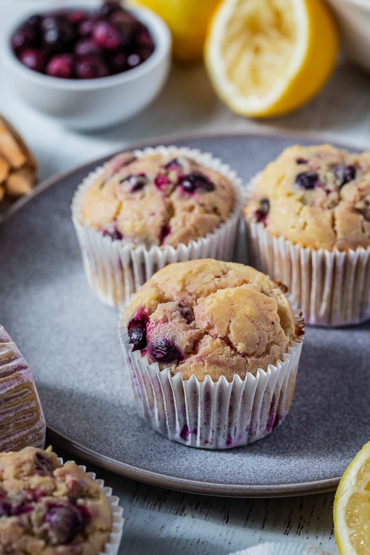 finished muffins on a plate with lemons and blueberries