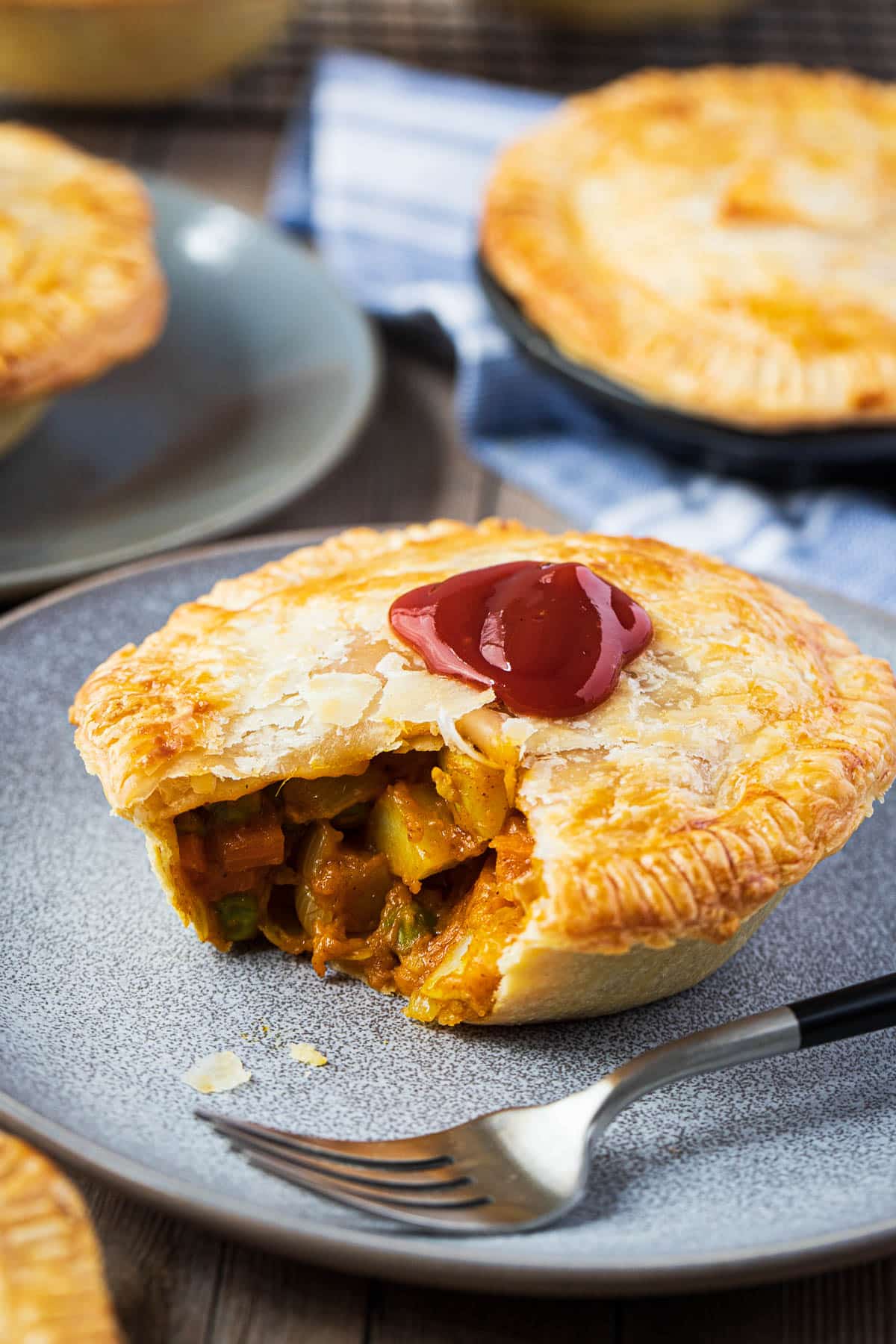 a curry pie on a grey plate with a fork