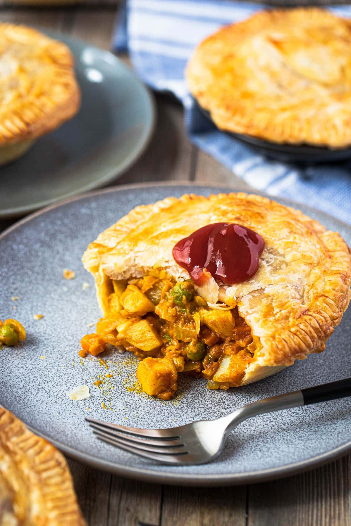 a pie filled with curry vegetable sauce on a grey plate
