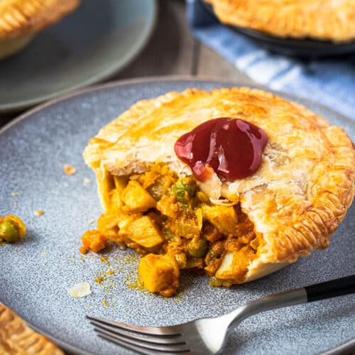 a curry pie filled with vegetables on a grey plate