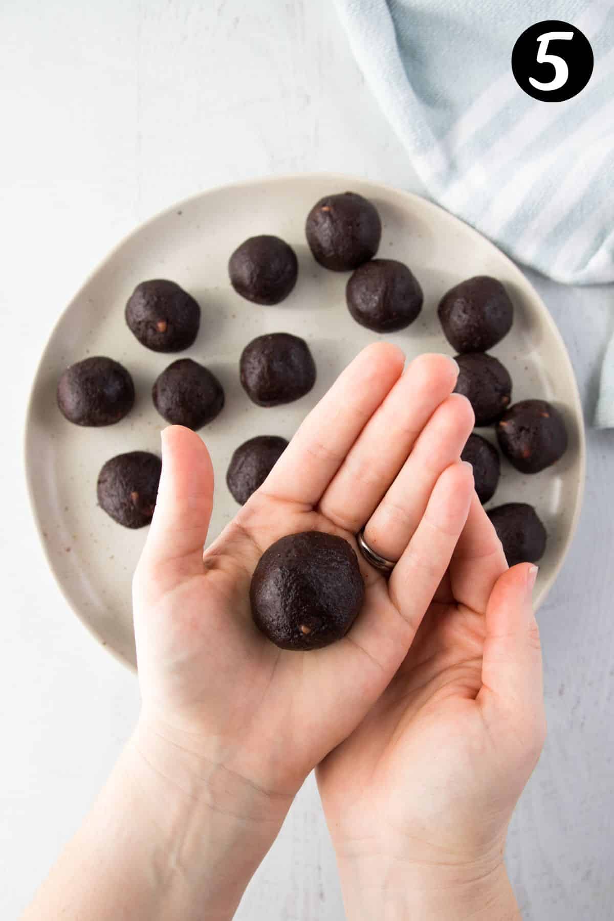 hands holding a ball of cookie dough