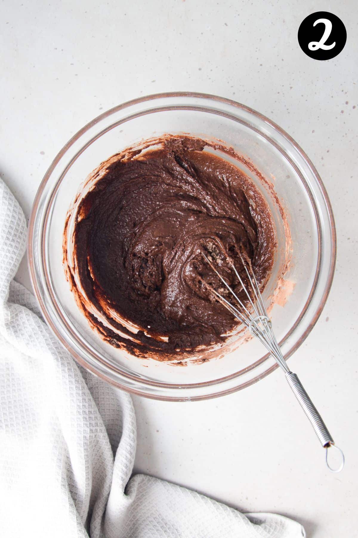 chocolate cupcake batter in a mixing bowl with a whisk.