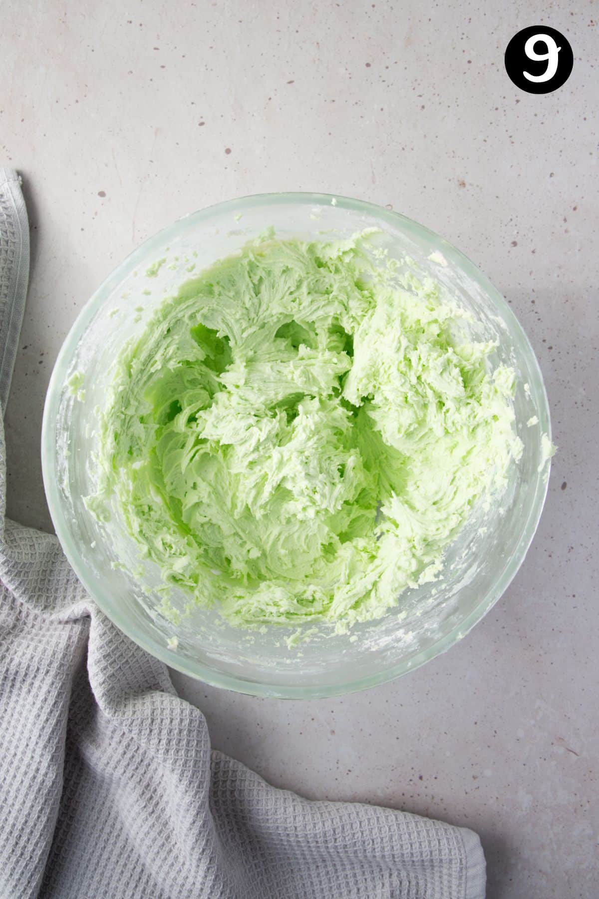 green mint buttercream frosting in a glass bowl.