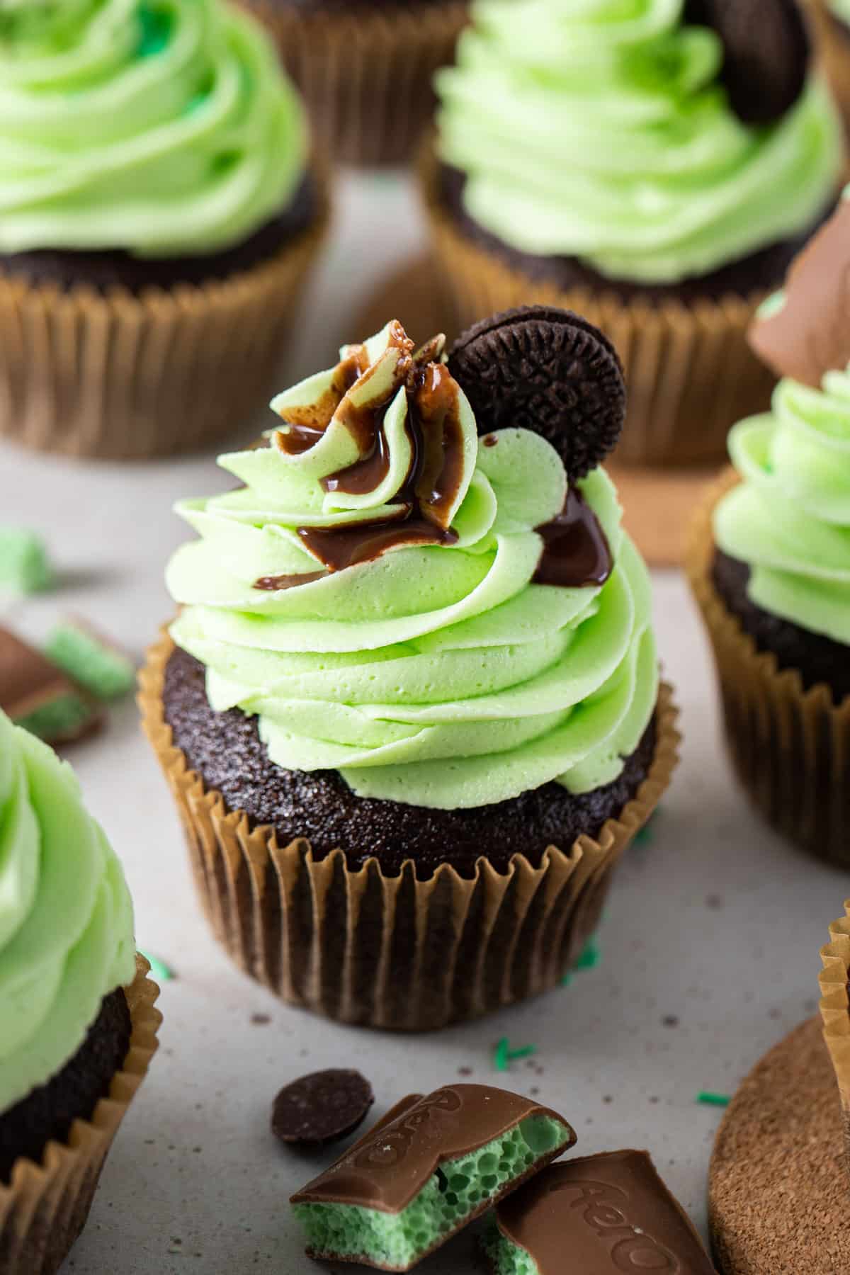 cupcakes topped with mint buttercream on a table.