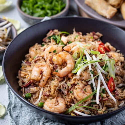 a bowl of fried rice topped with prawns and spring onion
