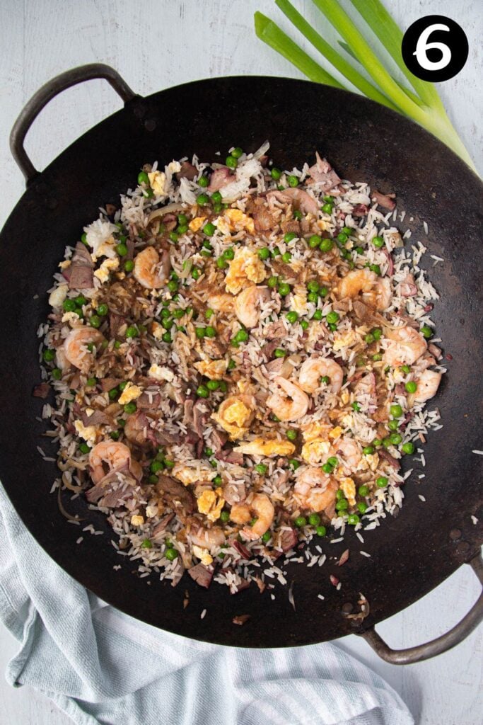 fried rice in a wok with sauce added