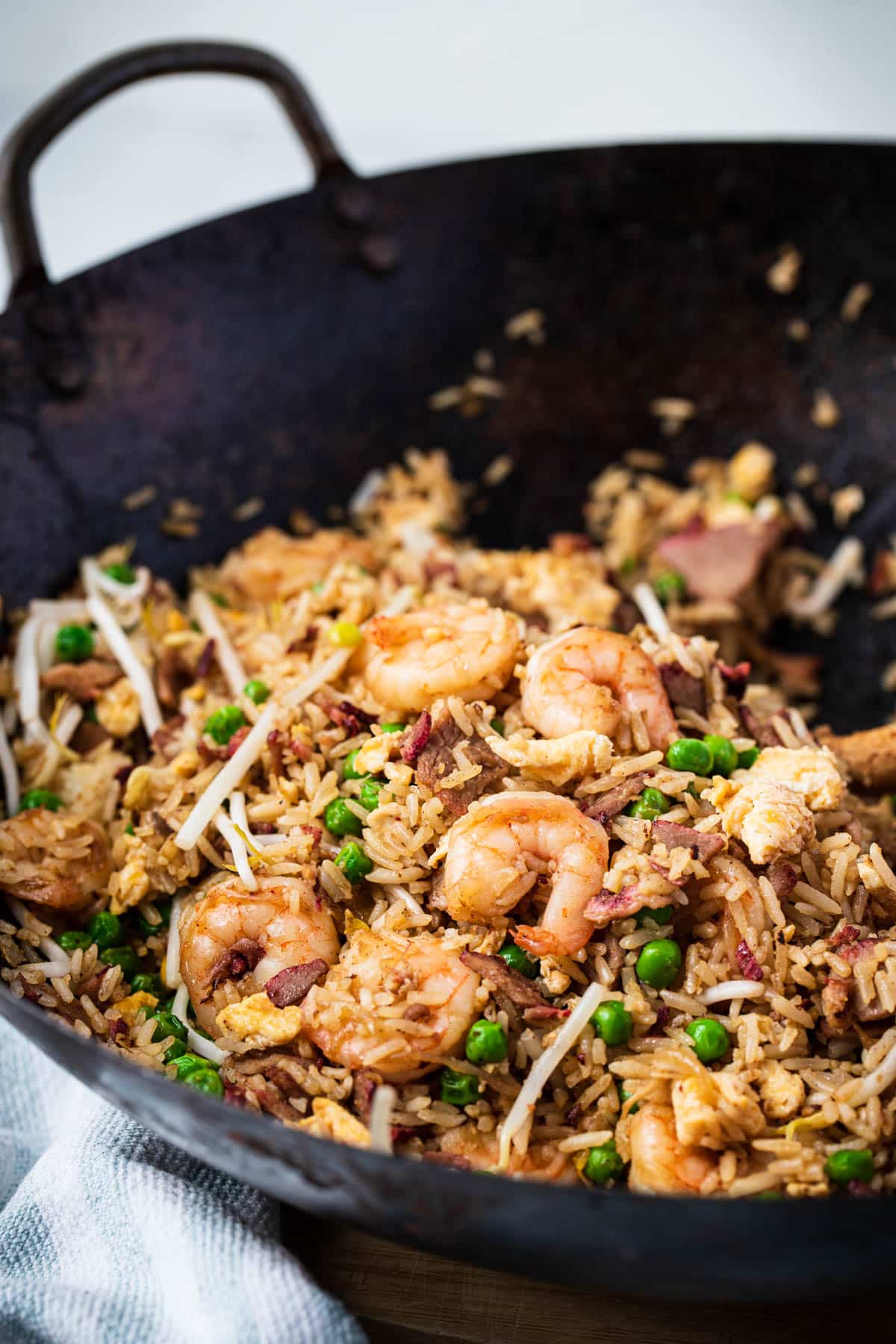 a wok with fried rice and prawns.