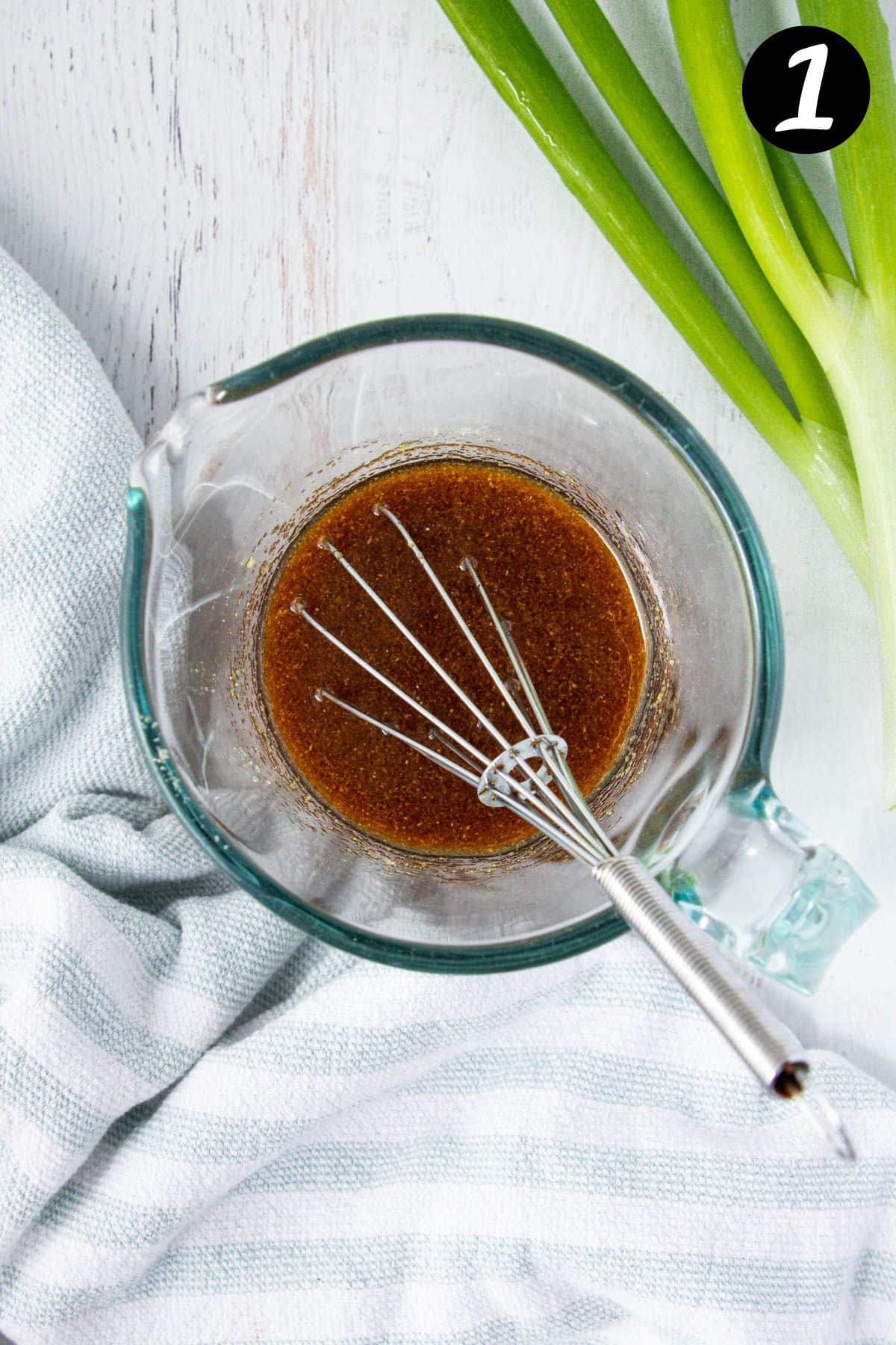 a jug of sauce for fried rice, with a whisk.