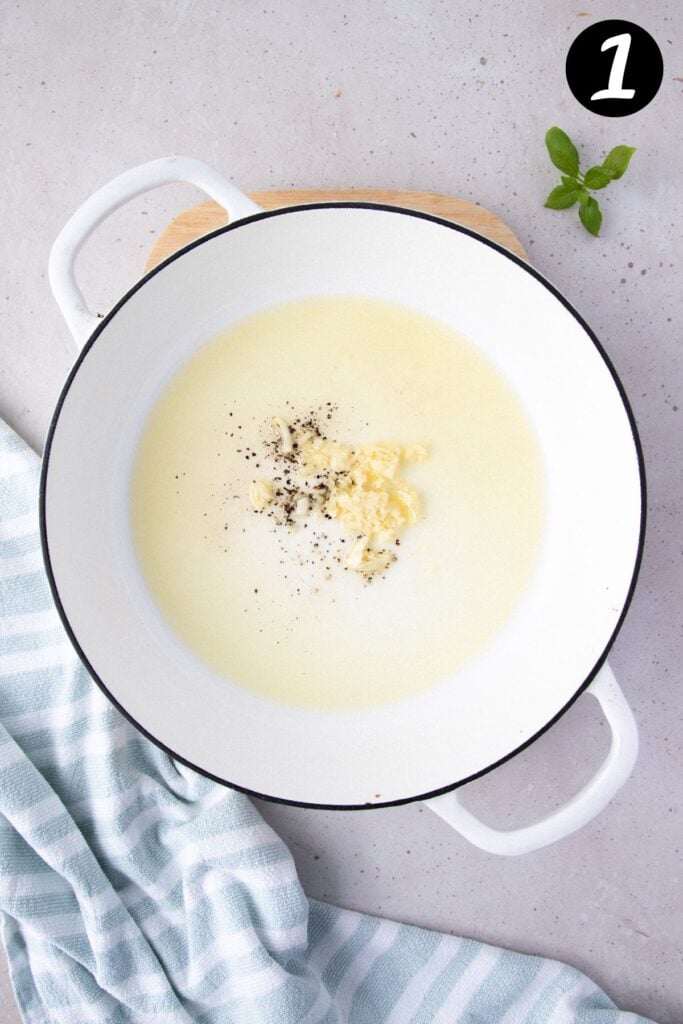 garlic and olive oil in a white pan.