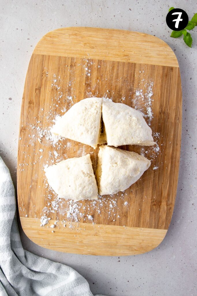 gnocchi dough cut into four even portions on a board.