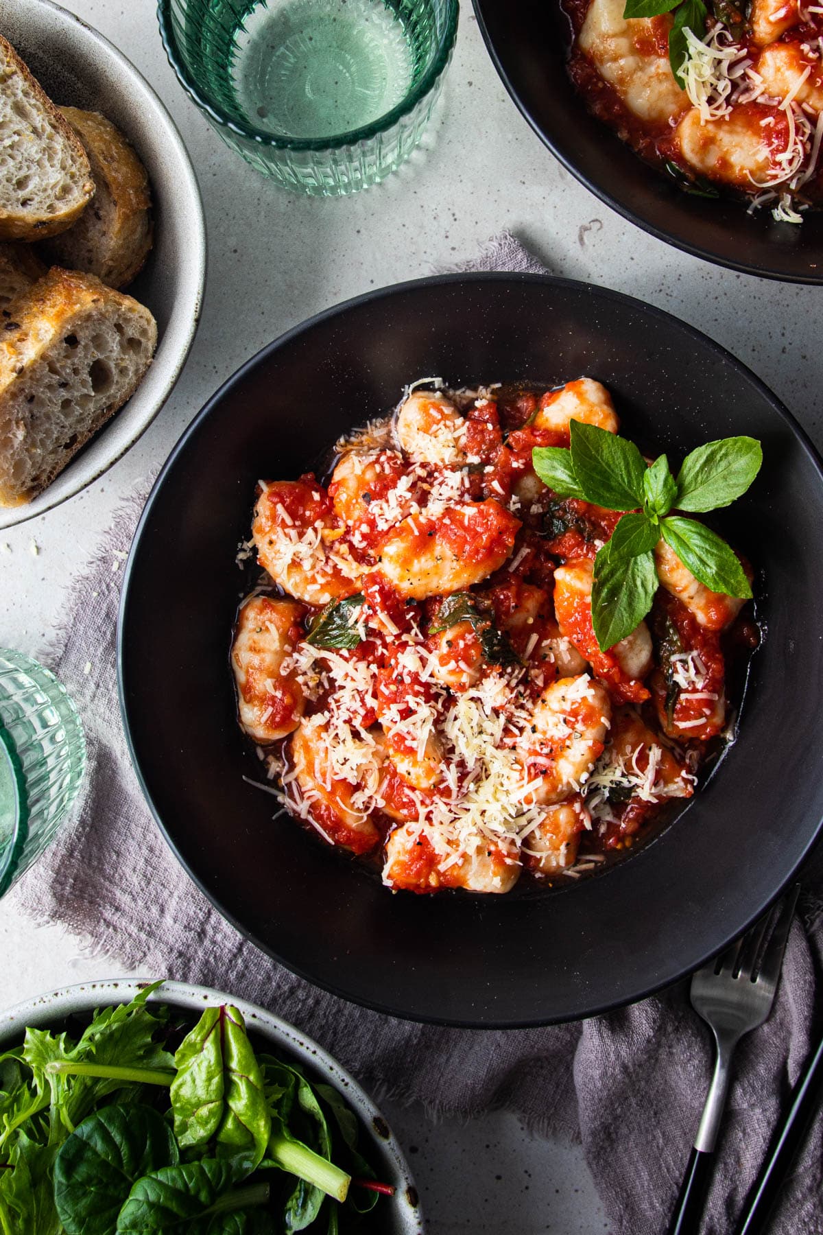 ricotta gnocchi in a bowl with cheese and basil.