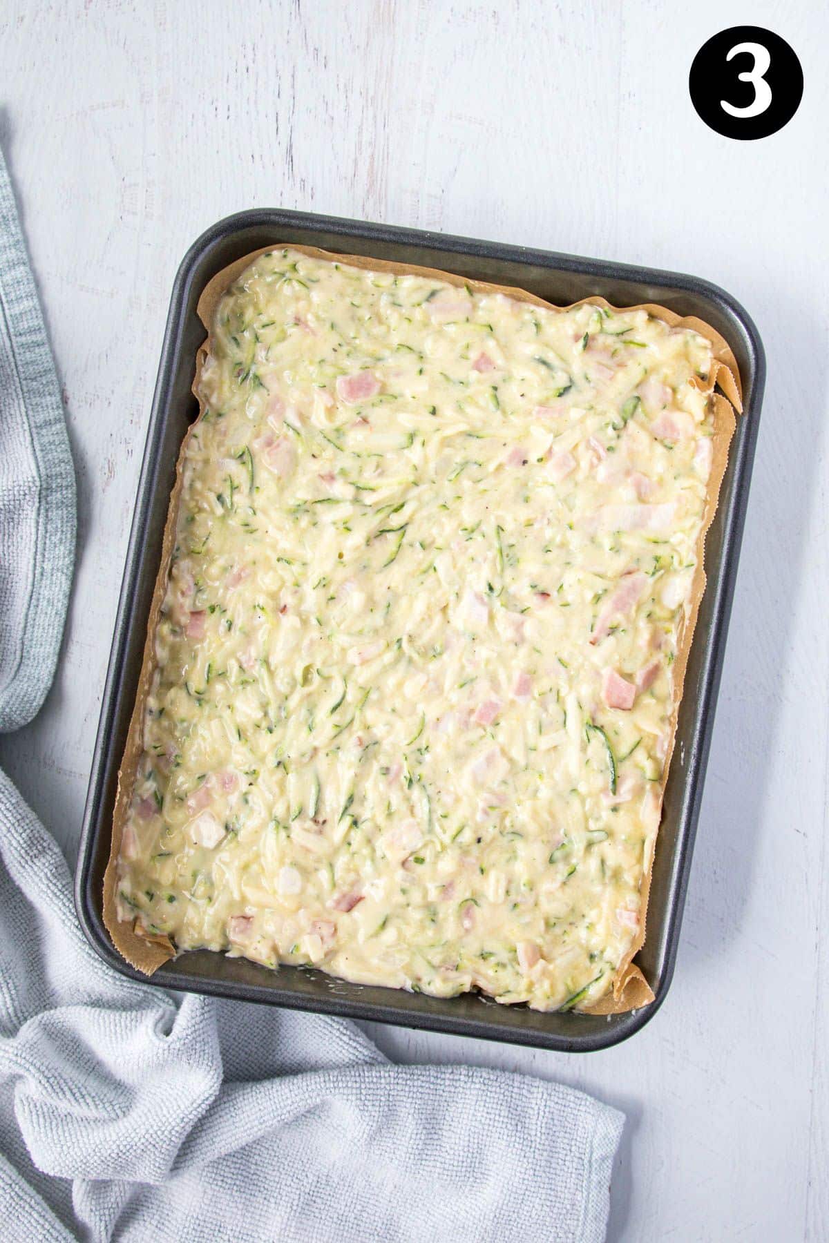 zucchini slice batter in a rectangular baking tin