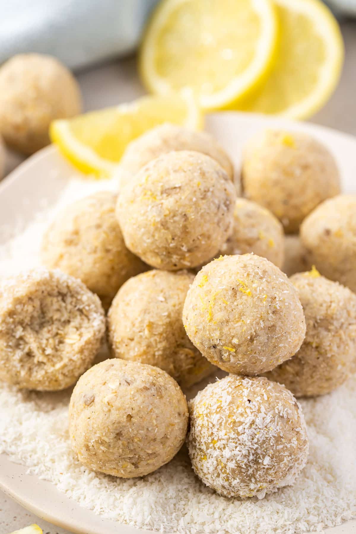 bliss balls on a white plate with lemon slices.