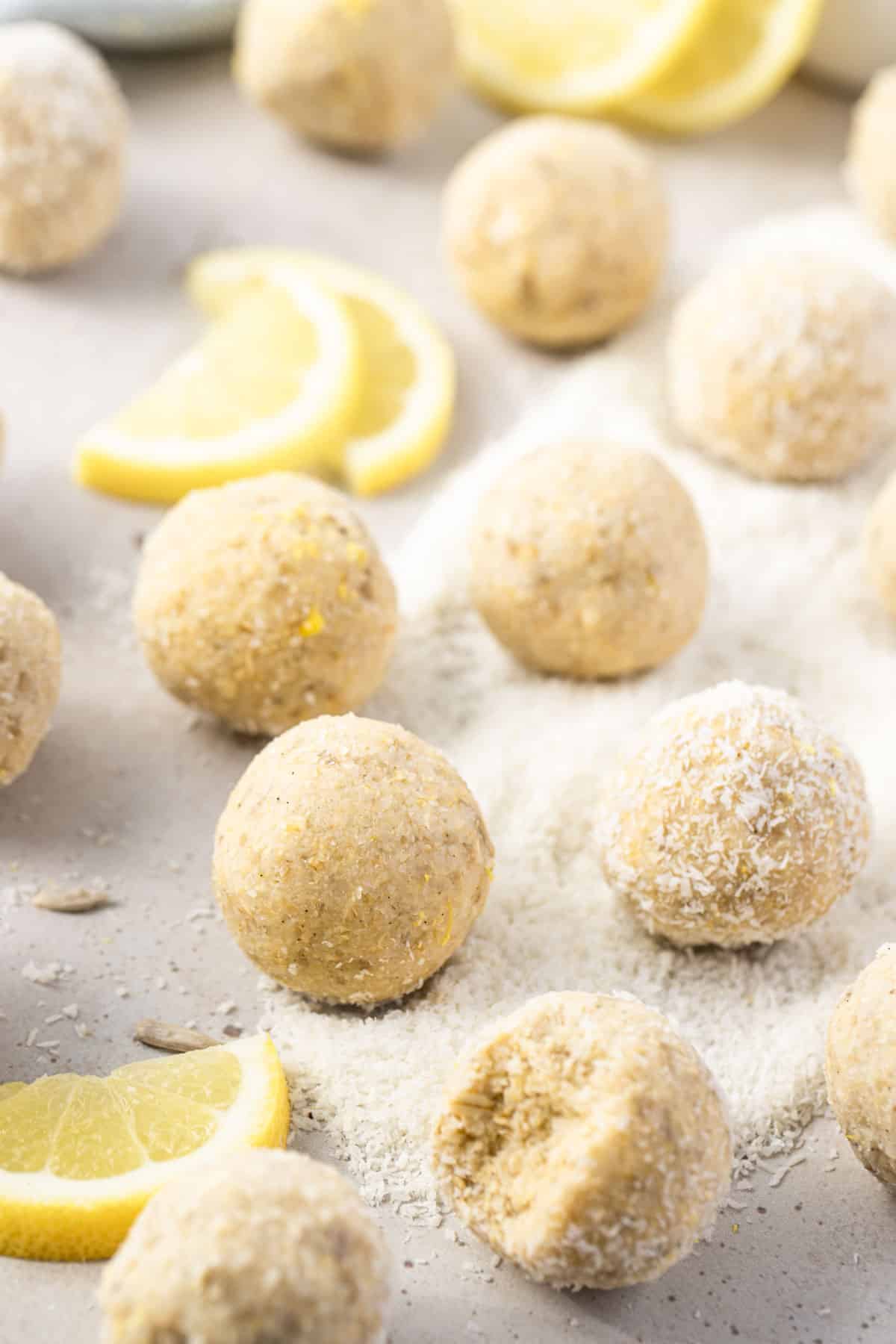 lemon and coconut energy balls, on a table with slices of lemon.