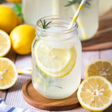 lemon cordial in a glass jar with lemon slices and a straw.