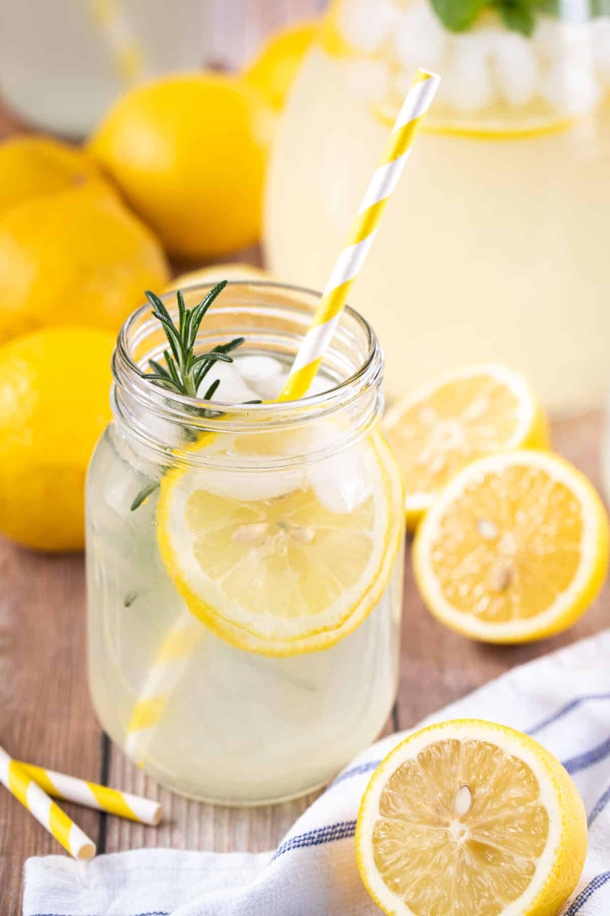 a glass containing lemon cordial with a yellow straw.