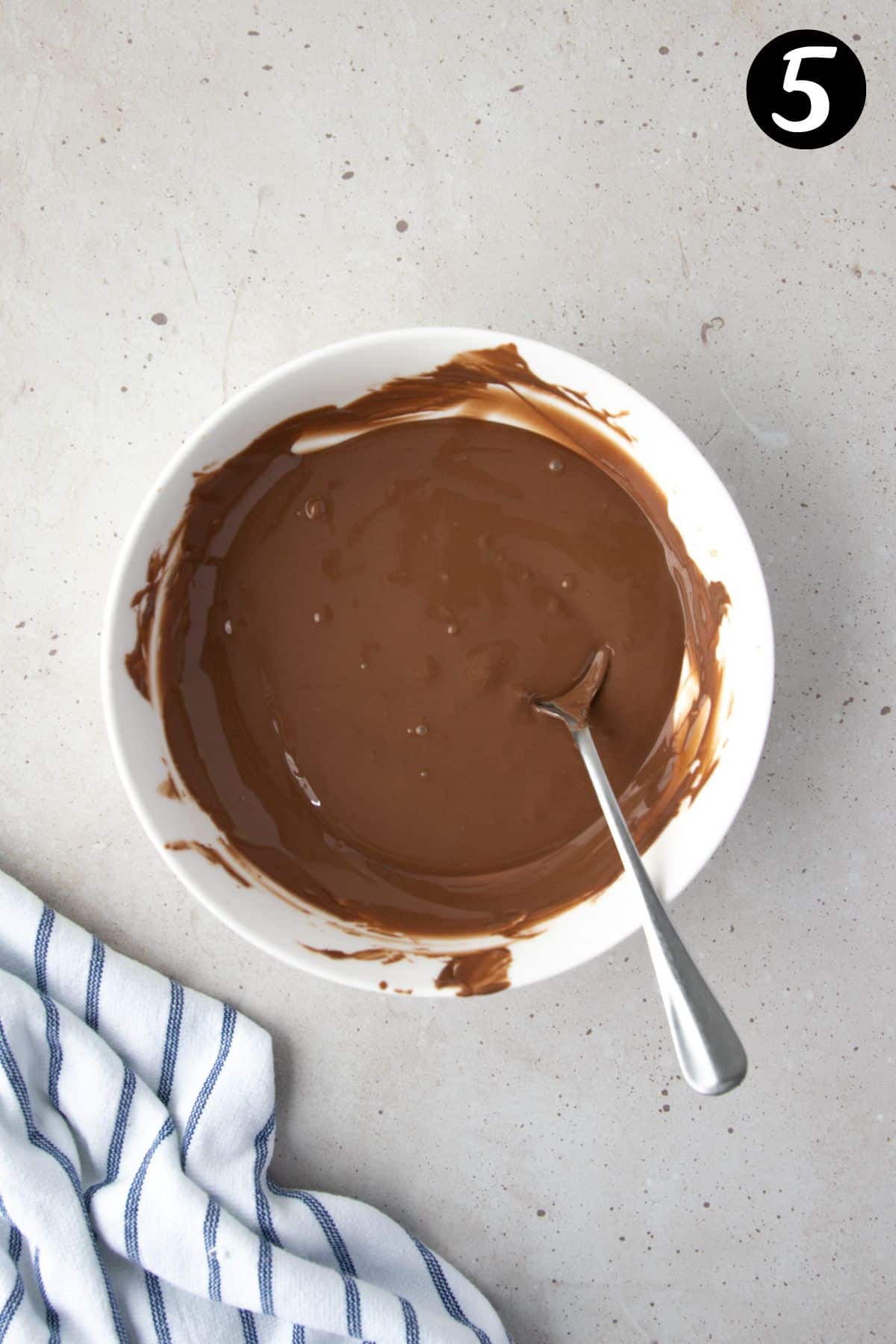 melted chocolate in a white bowl with a spoon.