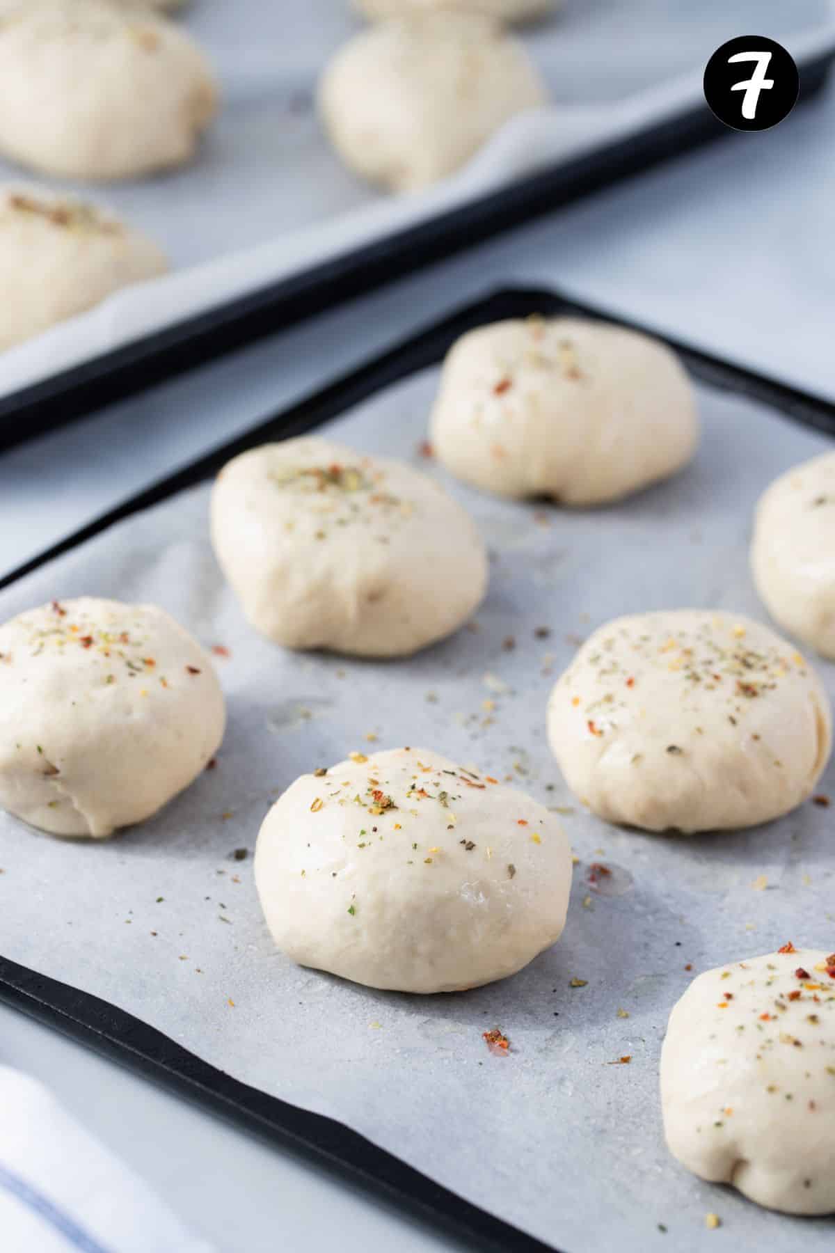 pizza pockets arranged on a baking tray, lined with baking paper.