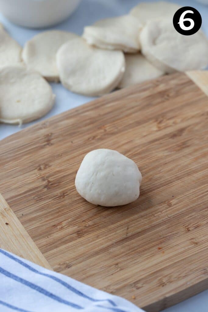 an uncooked pizza pocket sitting on a wooden board.