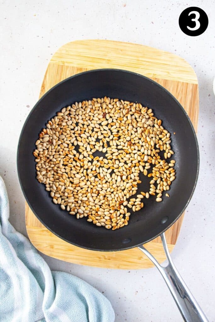 a pan with toasted pine nuts.