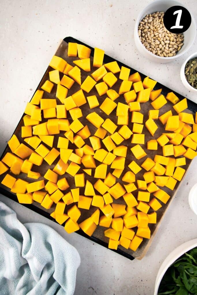 diced, raw pumpkin on a baking tray.