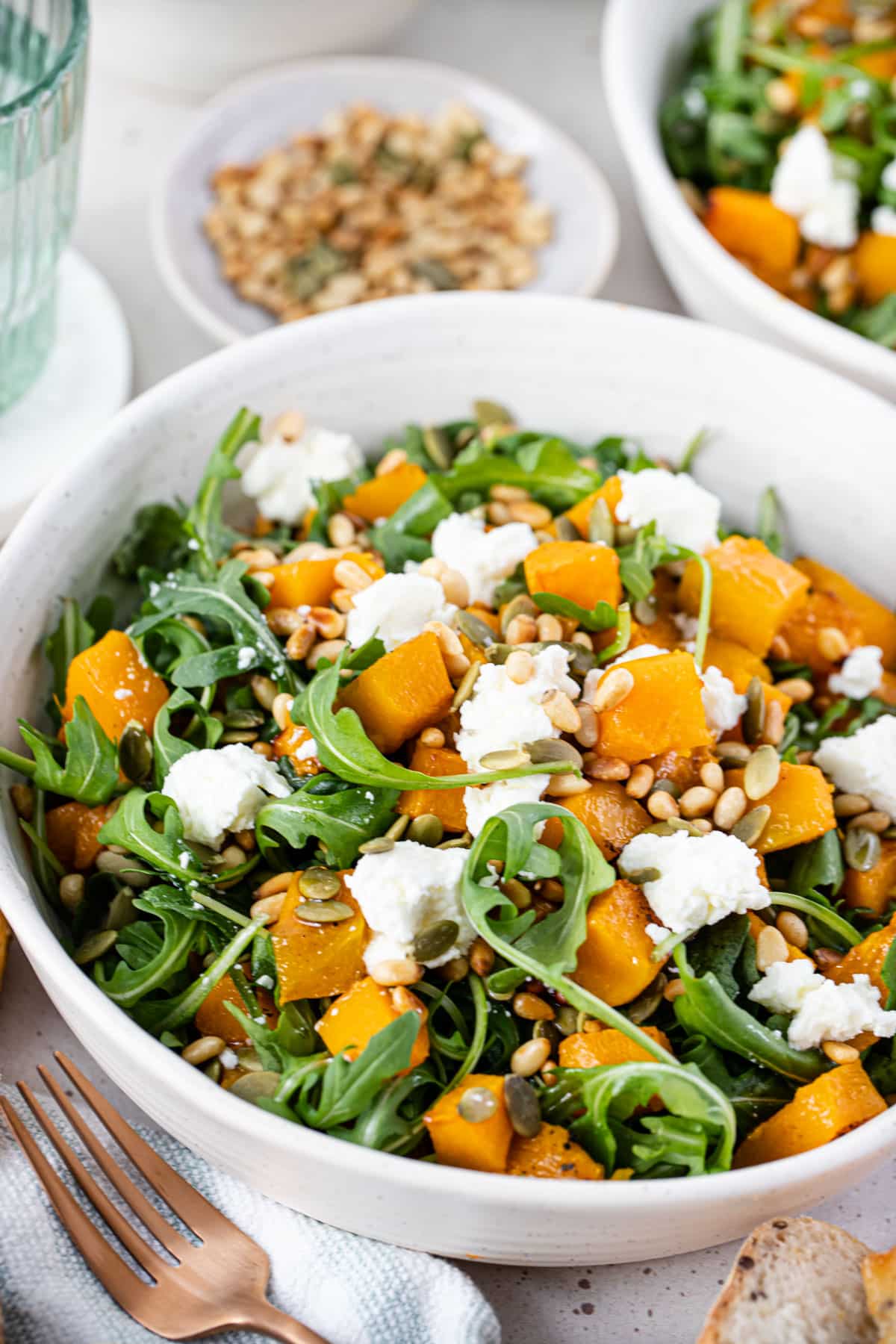 a bowl of salad with roasted pumpkin, rocket, goat cheese and pine nuts.