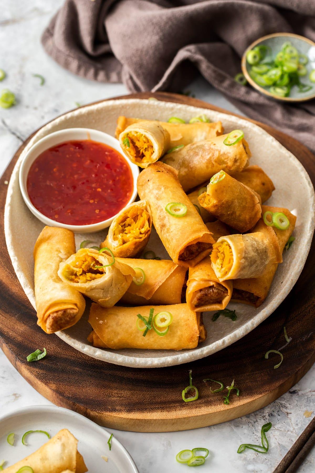 vegetable spring rolls on a plate with a dish of sweet chilli sauce.