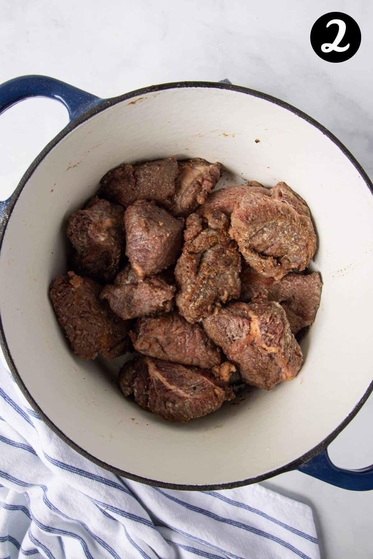 seared beef cheeks in a Dutch oven.
