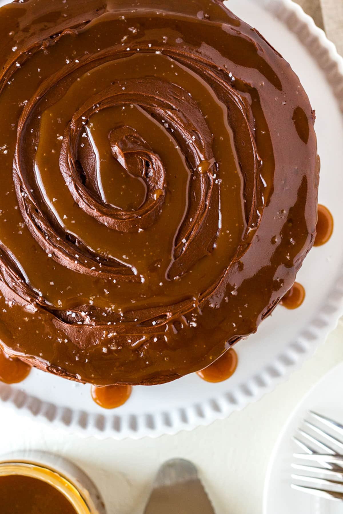 top view of a chocolate cake topped with buttercream frosting and caramel sauce dripping down the sides.