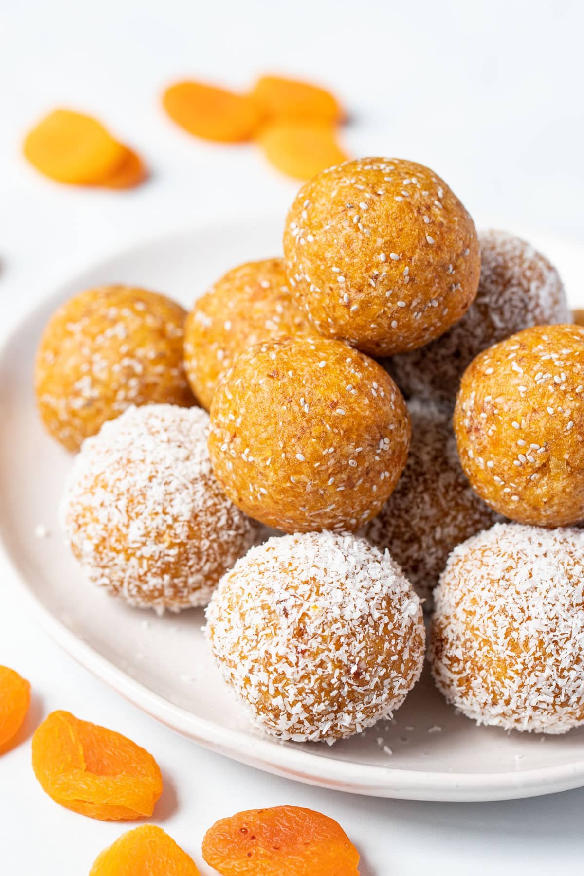 apricot balls on a plate with dried apricots on a table.